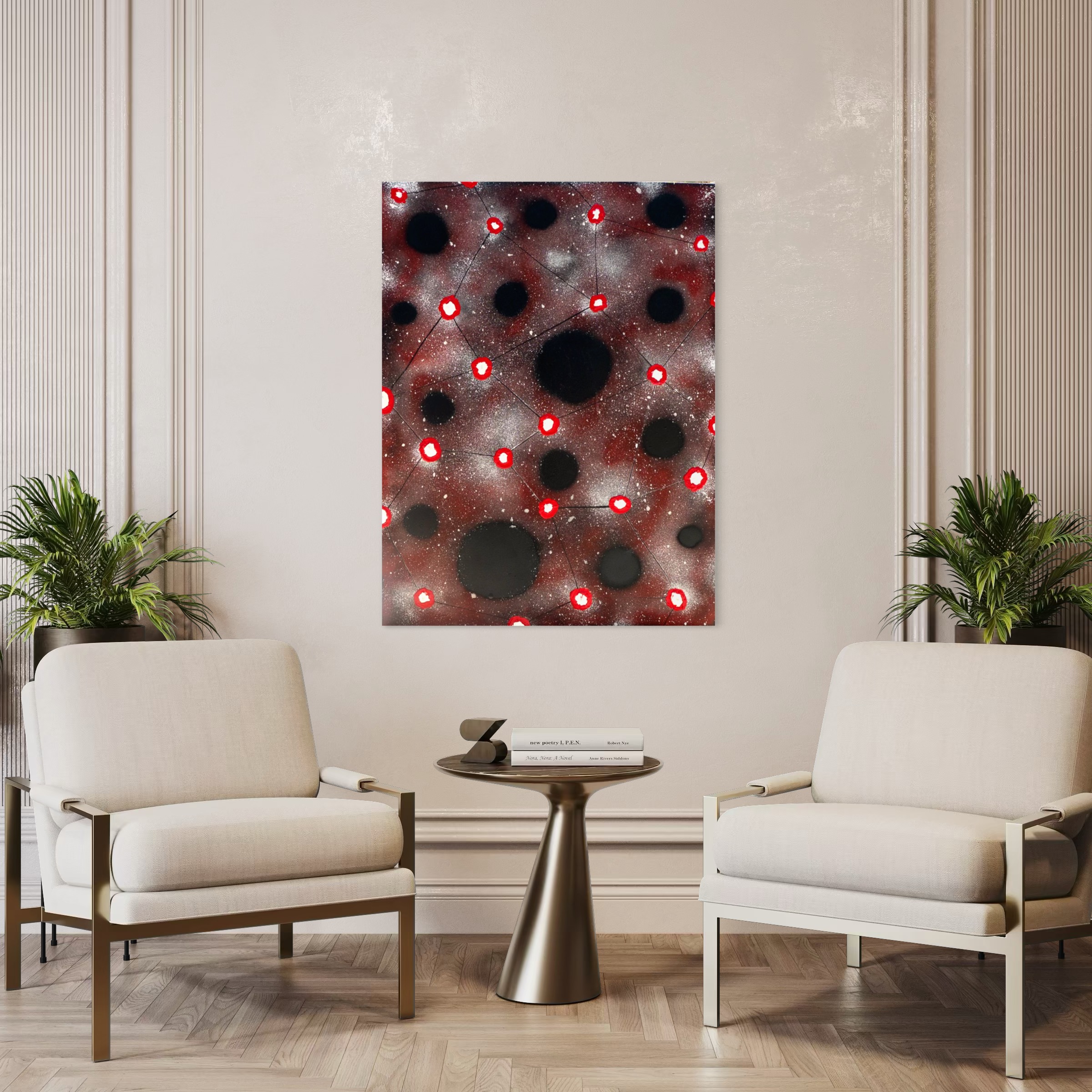 Two cream upholstered lounge chairs facing a small round brass table in a modern living room, with abstract red-and-black wall art between them and plants at the sides.