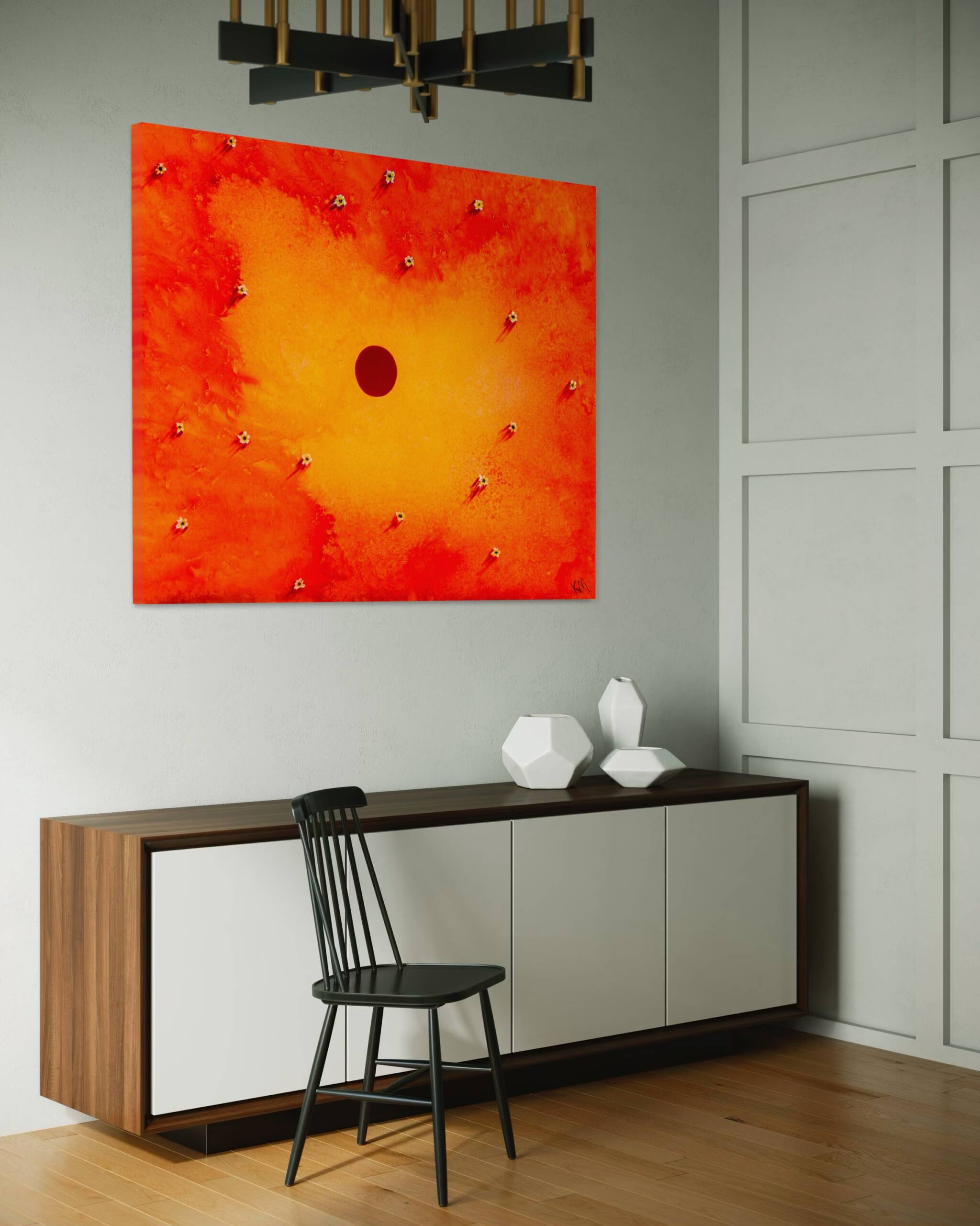 Orange-red abstract painting on a light gray wall above a two-toned wood-and-white cabinet; a black metal chair in front and white geometric vases on the cabinet, with part of a modern chandelier visible overhead.