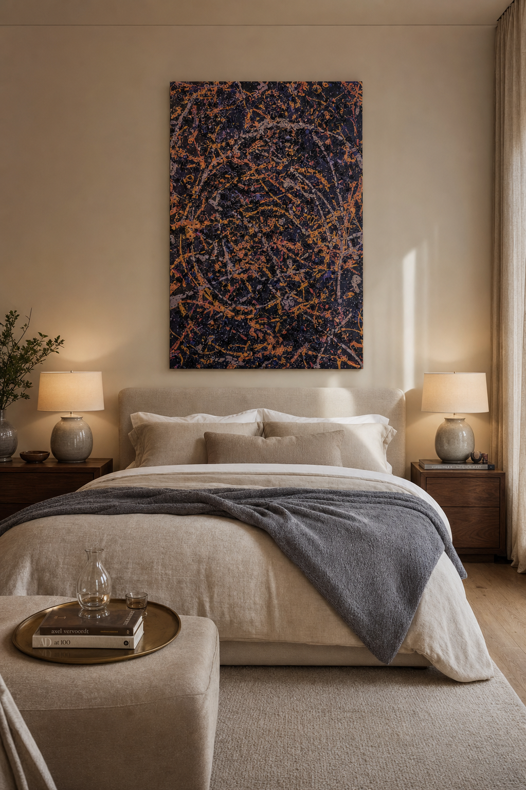 Neutral, softly lit bedroom with a beige upholstered bed, matching pillows, and a dark-blue and orange abstract painting above the headboard; two wooden nightstands with lamps flank the bed.