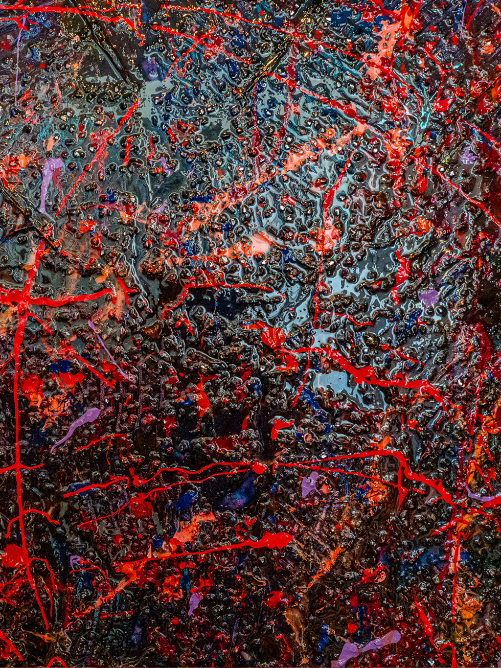 Close-up of an abstract drip-painting with tangled red lines over a dark, textured background in blues, blacks, and oranges.